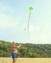The man is launching a big kite snake over blue sky Royalty Free Stock Photo